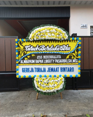 Papan Bunga Duka di Tanah Miring